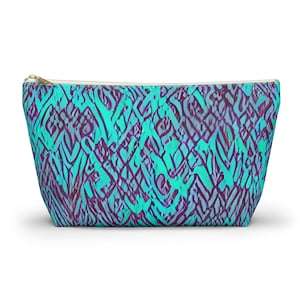 May include: A teal and purple zippered pouch with an abstract geometric pattern.