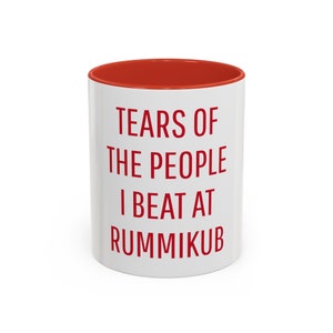 May include: White ceramic mug with a red rim. The mug has red text that reads "Tears of the people I beat at Rummikub".