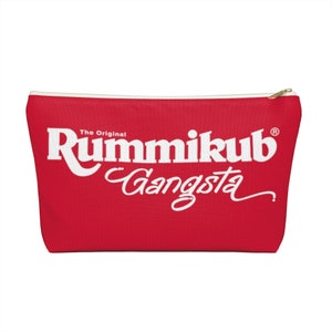 May include: Red zippered pouch with the text "The Original Rummikub Gangsta" in white.