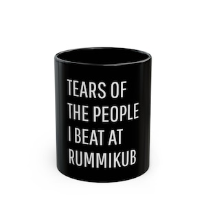 May include: Black coffee mug with white text that reads "Tears of the people I beat at Rummikub".