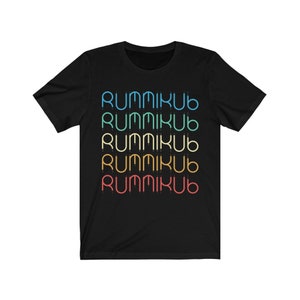 Puede incluir: Camiseta negra con la palabra "Rummikub" repetida cinco veces en un arcoíris de colores.