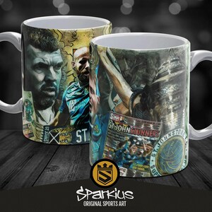 May include: A white ceramic mug with a colourful collage design featuring a sports team logo, player portraits, and newspaper clippings. The mug has a handle and the text "ST. JOHNSTONE" is visible on the design.