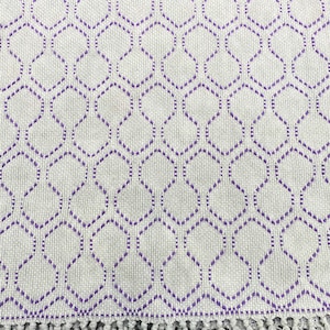 May include: A white throw blanket with a purple geometric pattern and a fringe border.