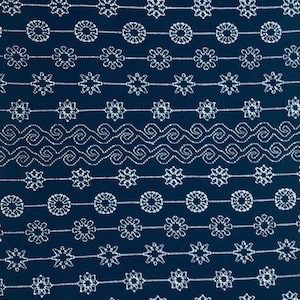 May include: A dark blue fabric with a white repeating pattern of circles, stars, and wavy lines.