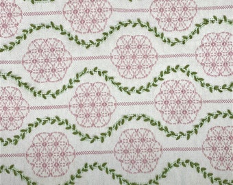 May include: White fabric with a pink and green embroidered design. The design features repeating circles with a floral pattern and green vines.