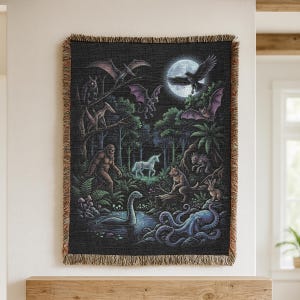 May include: A black tapestry featuring a fantasy forest scene with a full moon, a unicorn, Bigfoot, and other mythical creatures. The tapestry has a fringed border and is hanging on a wall.