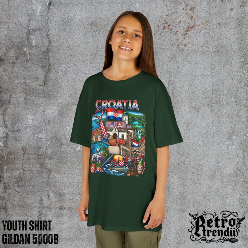 A young girl wearing a Green T-shirt featuring a colorful graphic design of Croatia landmarks and symbols, including a Dalmatian dog, necktie, Mediterranean coast, and historic architecture.