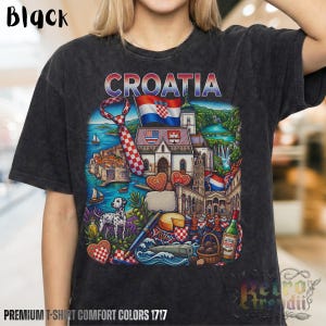 A person wearing a black acid-wash T-shirt featuring a colorful graphic design of Croatia landmarks and symbols, including a Dalmatian dog, necktie, Mediterranean coast, and historic architecture, showcasing European culture.
