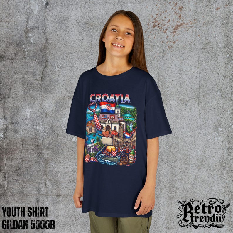 A young girl wearing a blue T-shirt featuring a colorful graphic design of Croatia landmarks and symbols, including a Dalmatian dog, necktie, Mediterranean coast, and historic architecture.