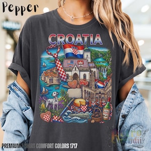 A person wearing a grey pepper acid-wash T-shirt featuring a colorful graphic design of Croatia landmarks and symbols, including a Dalmatian dog, necktie, Mediterranean coast, and historic architecture, showcasing European culture.