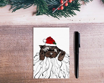 A6 Christmas card illustrated with a dog disguised as Santa Claus drawn in black ink and printed in limited edition