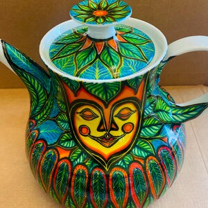 Puede incluir: Una taza de cerámica blanca con un asa negra y el texto "But First, Coffee" en negro y negrita. La taza está sobre una superficie blanca. La taza mide aproximadamente 10 cm de alto.