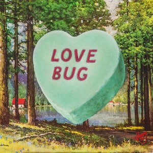 May include: A green heart-shaped candy with the words "LOVE BUG" in red lettering. The candy is in front of a painting of a forest scene with a lake and a small red cabin.