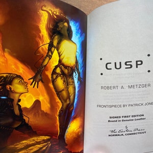 May include: A book cover with a fiery orange and blue background. The cover features a woman with long red hair and a man with blue skin. The title of the book is "CUSP" and the author is "ROBERT A. METZGER". The book is a signed first edition, bound in genuine leather, and published by The Easton Press.