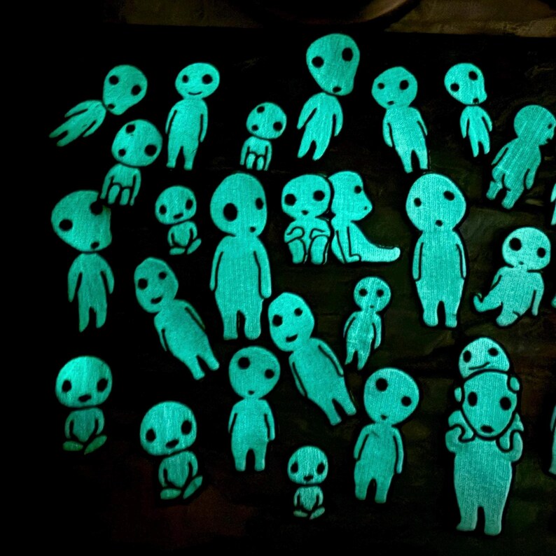 May include: A collection of numerous small, glowing cyan figures with rounded heads and simple facial features arranged against a dark background. Each figure displays a distinct posture, with some standing, sitting, or leaning, all emitting a bright light.