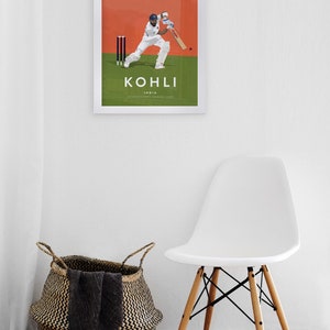 Pode incluir: Um p&ocirc;ster emoldurado com fundo branco e uma ilustra&ccedil;&atilde;o laranja e verde de um jogador de cr&iacute;quete em a&ccedil;&atilde;o. O p&ocirc;ster tem o texto "KOHLI" em letras pretas e "India" em letras pretas menores abaixo. O texto "INTERNATIONAL CRICKET.COM" est&aacute; em letras pretas ainda menores abaixo de "India".