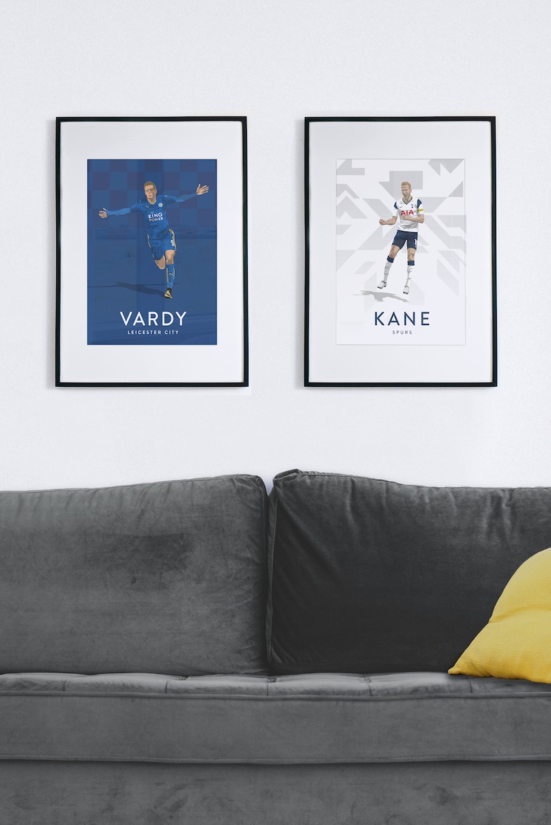 Pode incluir: Dois cartazes emoldurados de jogadores de futebol profissionais. O cartaz &agrave; esquerda apresenta Jamie Vardy com um uniforme de futebol azul com o texto "VARDY LEICESTER CITY". O cartaz &agrave; direita apresenta Harry Kane com um uniforme de futebol branco com o texto "KANE SPURS".