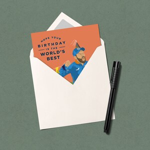 May include: A birthday card with an orange background featuring a cartoon illustration of a person wearing a blue shirt and a party hat. The text on the card reads "Hope your birthday is the world's best."