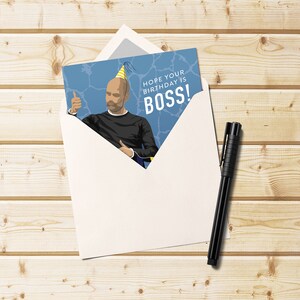 May include: A birthday card with a cartoon illustration of a person wearing a party hat and giving a thumbs up. The card has the text "Hope your birthday is BOSS!"