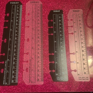 May include: Four clear plastic and black page finders with rulers and holes for a binder. The rulers are marked with numbers from 1 to 20. The page finders have the text "TODAY" and "FOR DAILY USE QUICK PAGE FINDER" printed on them.