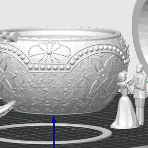 May include: A white ceramic trinket box with an ornate design and a hinged lid. The box is open and the inside is visible. The box is decorated with a floral pattern and has a pearl-like trim.