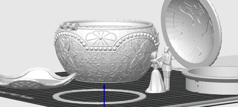 May include: A white ceramic trinket box with an ornate design and a hinged lid. The box is open and the inside is visible. The box is decorated with a floral pattern and has a pearl-like trim.