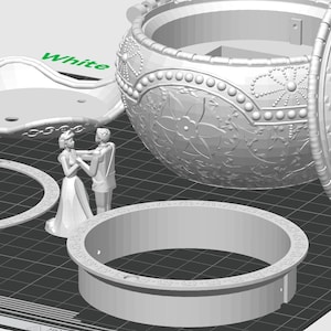 May include: A white 3D printed music box with a lid that opens to reveal a couple dancing inside. The music box is decorated with intricate details and has a ring-shaped base.