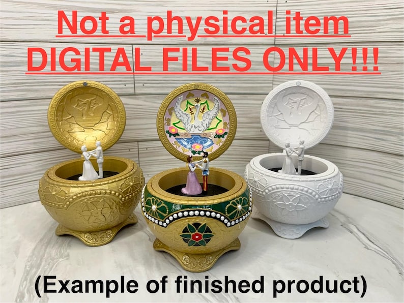 May include: Three music boxes with different designs. The top of each box is open, revealing a small figurine of a couple dancing inside. The boxes are decorated with gold, white, and green paint. The text "Not a physical item DIGITAL FILES ONLY!!" is displayed at the top of the image. The text "(Example of finished product)" is displayed at the bottom of the image.