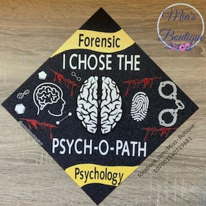 Op de afbeelding: Zwarte afstudeerhoed met gouden glitteraccenten. De hoed heeft de tekst "Forensic I CHOSE THE PSYCH-O-PATH Psychology" en een witte hersenafbeelding.