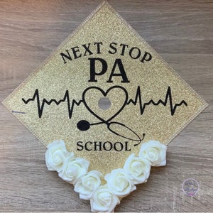May include: Gold glitter graduation cap with black text that reads "Next Stop PA School" with a heart and stethoscope graphic.