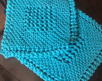 May include: Two turquoise blue knitted dishcloths with a lacy pattern.