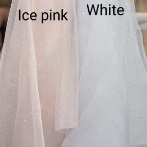 May include: Two rolls of fabric, one in ice pink and the other in white, both with a subtle glitter effect. The text "Ice pink" and "White" are visible on the fabric. The fabric appears to be lightweight and suitable for various craft projects.