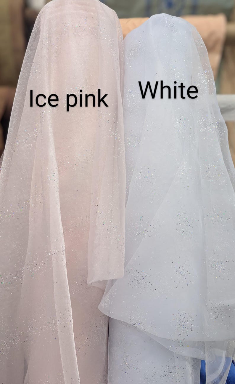 May include: Two rolls of fabric, one in ice pink and the other in white, both with a subtle glitter effect. The text "Ice pink" and "White" are visible on the fabric. The fabric appears to be lightweight and suitable for various craft projects.