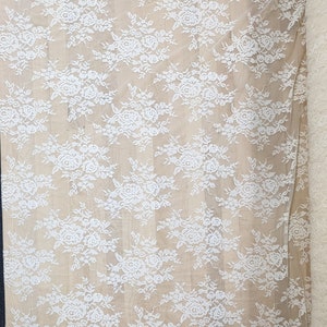 May include: White lace fabric with a floral pattern. The lace is delicate and sheer, with a soft, flowing texture.