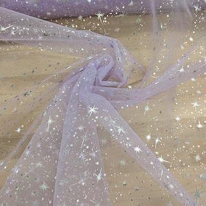 May include: Lilac tulle fabric with silver glitter stars. The fabric is sheer and has a delicate texture.