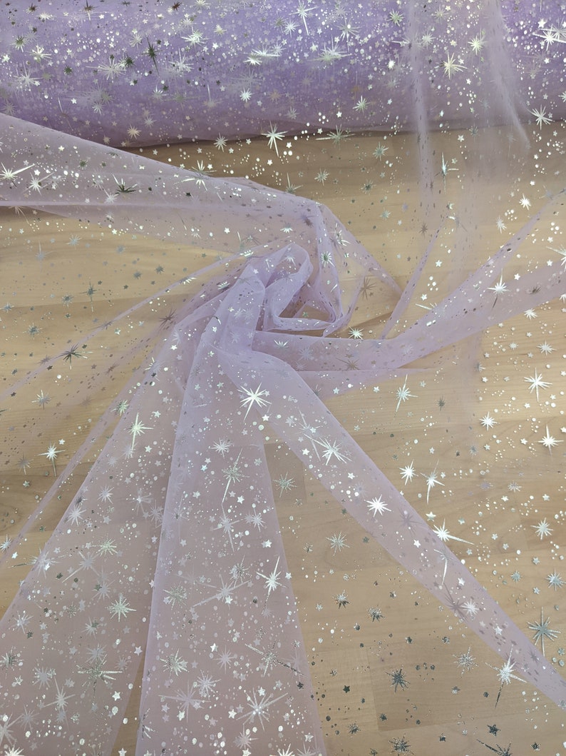 May include: Lilac tulle fabric with silver glitter stars. The fabric is sheer and has a delicate texture.