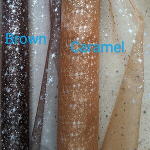 May include: Three rolls of sheer fabric with a silver star pattern. The fabric is brown, caramel, and a lighter brown color.