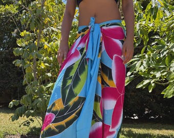 Falda pareo envolvente tropical con diseño hawaiano, color azul turquesa y multicolor, con flores de plumeria pintadas a mano