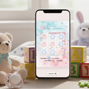 May include: A smartphone displays a baby shower game with the text "Fille ou Garcon?" in a watercolor style. The game features images of baby clothes. A teddy bear, blocks, and a pacifier are in the foreground.