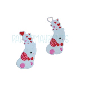 May include: Two white elephant figurines with red hearts and a bow tie. The elephants are standing on their hind legs and have a pink heart on their bottom.