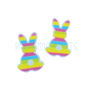 May include: Two colorful Easter bunny shaped stickers with pink, yellow, blue and green stripes. The bunnies are sitting with their tails in the air.