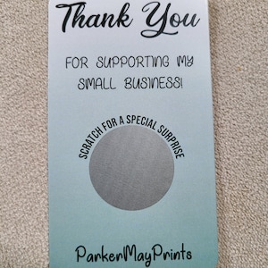 May include: A rectangular card with rounded corners, featuring a gradient of white to teal. The card reads "Thank You" in cursive, followed by "FOR SUPPORTING MY SMALL BUSINESS!" and "SCRATCH FOR A SPECIAL SURPRISE."