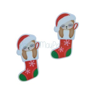 May include: Two red and green Christmas stockings with a white snowflake pattern. Each stocking has a brown sloth wearing a red Santa hat inside.