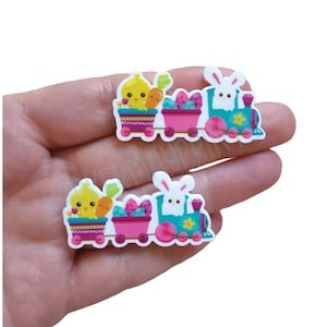 May include: A colorful Easter train with a chick and bunny riding in the cars. The train is decorated with flowers and eggs.
