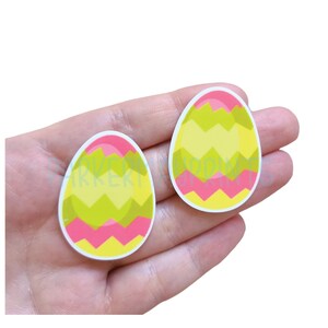 May include: Two colorful Easter egg stickers with a pink, yellow, and green chevron pattern.