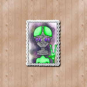 May include: A green alien with a peace sign hand gesture, wearing a black and white patterned gas mask, on a postage stamp.
