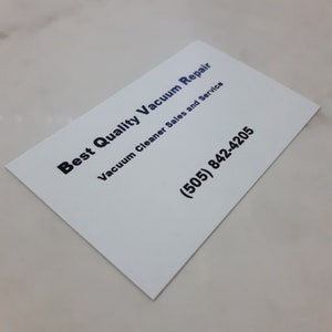 May include: White business card with black text that reads "Best Quality Vacuum Repair" and "Vacuum Cleaner Sales and Service". The phone number (505) 842-4205 is printed in black.