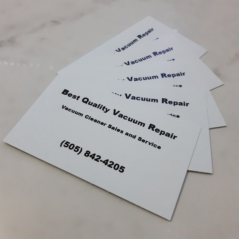 May include: A stack of white business cards with black text. The top card reads "Vacuum Repair" and the bottom card reads "Best Quality Vacuum Repair, Vacuum Cleaner Sales and Service (505) 842-4205".