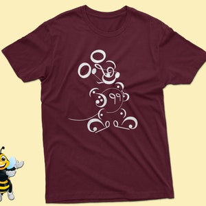 May include: Burgundy t-shirt with a white design of a cartoon character made of musical notes.