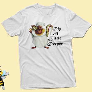 May include: White t-shirt with a cartoon image of a character holding a snake and the text "Dig A Little Deeper".